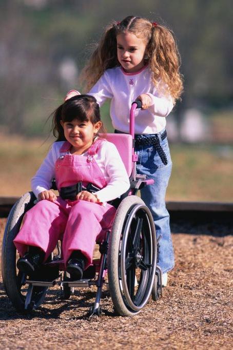 girl pushing friend in wheelchair
